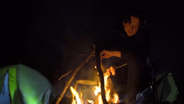 Campfire and camping tent at night.