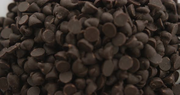 Video of close up of multiple chocolate chip over white background