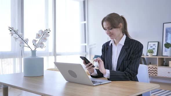 Woman Browsing on Smartphone at Work