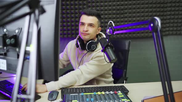 a Male Radio Dj in Between Broadcasts in a Radio Studio