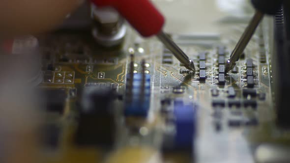 Man Technician Is Doing Repair of Computer Chip at Table in Service Office. Irrl