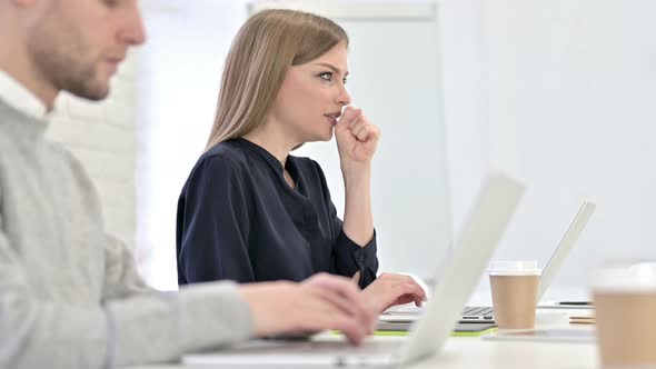 Creative Woman Working on Laptop and Coughing in Office