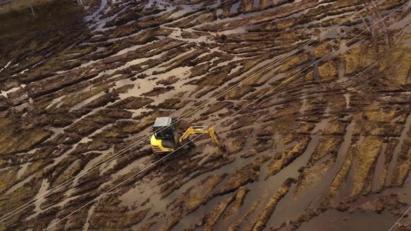 excavator drives in muddy field to work on solar power plant