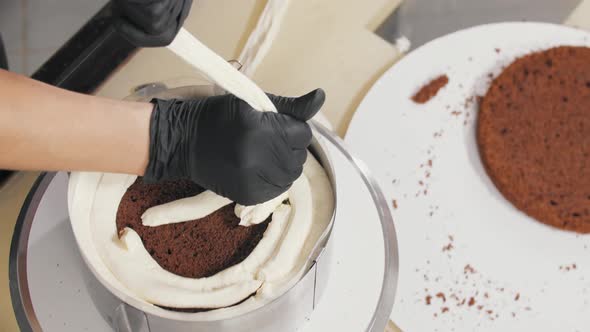 Confectioner Squeezes Vanilla Cream on the Top Part of the Bisquit Cake