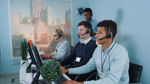 Black Phone Operator Helping His Colleague in Call Center