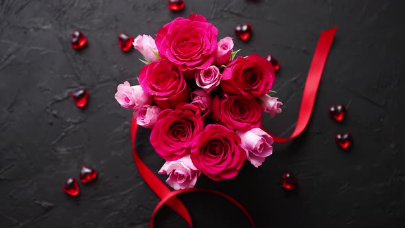 Pink Roses Bouquet Packed in Red Box and Placed on Black Stone Background