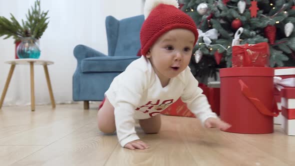 Cute Little Baby in Christmas Clothes Crawling on the Wooden Floor