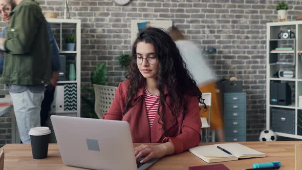 Zoom Out Time-lapse of Young Lady Using Laptop in Shared Office Focused on Job