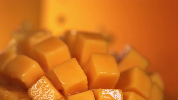 Slow Motion Shot of Mango Juice Splashing Through Mango Cube Slices