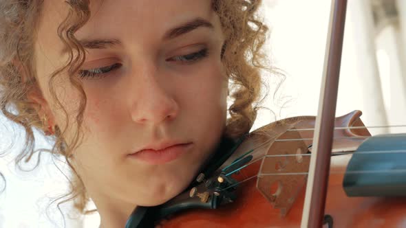 young curly blond woman the violinist: Musician playing violin