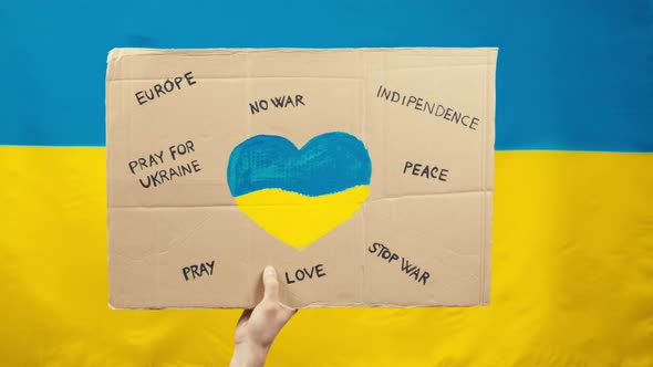 Sign Saying Peace and No War in Ukraine with Blue and Yellow Flag Background