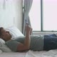 Young Handsome Man Lies in Bed By the Window Uses the Phone - VideoHive Item for Sale