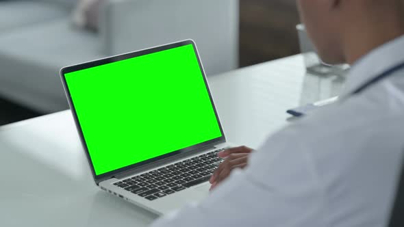 Rear View of African Doctor using Laptop with Open Screen