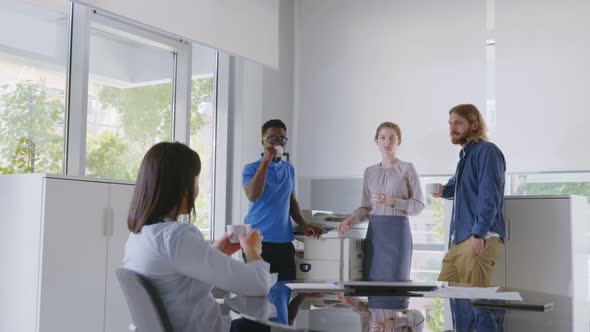 Group of Diverse Coworkers Having Coffee Break and Chatting in Office