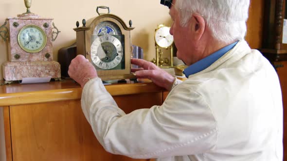 Portrait of smiling horologist adjusting watch