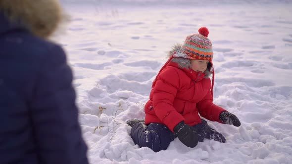 Little Boy Plays Snowballs with His Mother. Slowmotion Shot