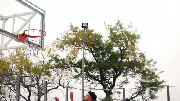 Young African Player Jumping Up and Hitting a Basketball Ring By His Hand