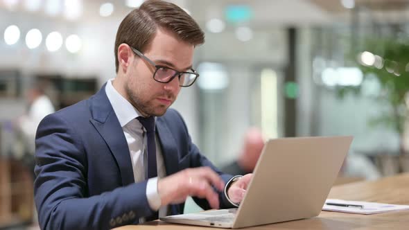 Businessman Reacting To Loss on Laptop at Work 