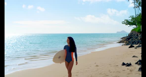 Female surfer walking with surfboard