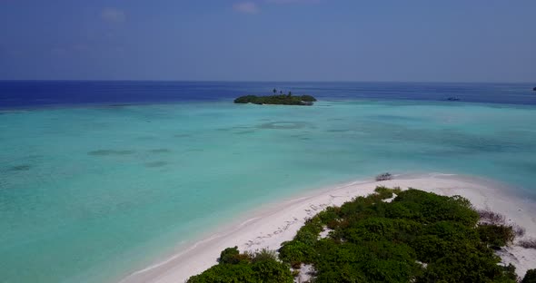 Wide angle fly over tourism shot of a sandy white paradise beach and blue water background in hi res