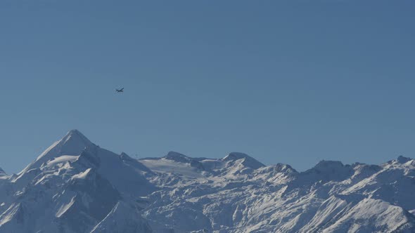 Plane flying above mountains covered in snow