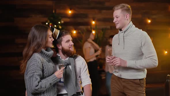 Young Man Talks To Couple in Celebrating New Years Eve Party in Decorated House