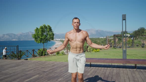 Slow Motion Shot of a Man Having Cardio Training Outdoors and Throwing Skipping Rope When Finishing