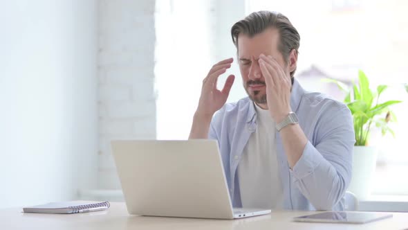 Young Man Having Headache While Working on Laptop