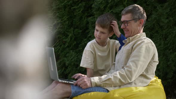 father with son using laptop at outdoor