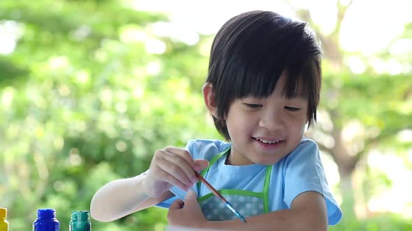 Cute Asian Boy Painting A Picture