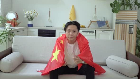 A Chinese Football Fan Watches TV at Home