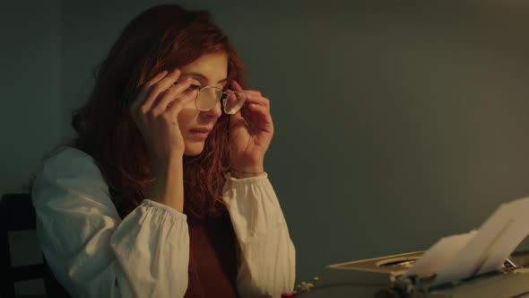 Girl Writes on the Typewriter at Home Sitting on the Table