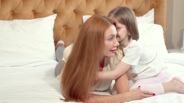 Cute Little Girl Enjoying Resting at Home with Her Mother