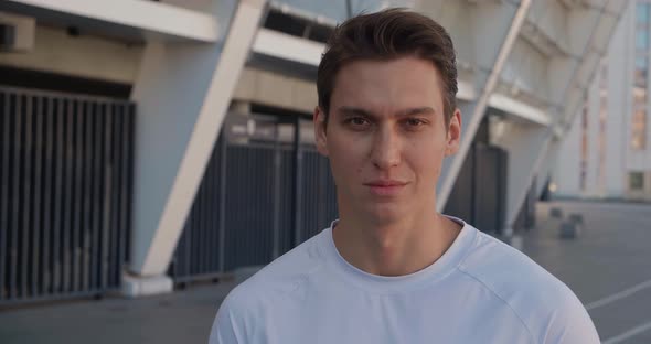 Portrait of a Confident Sporty Man Looking at the Camera in the Morning at the Stadium