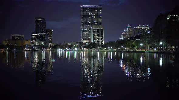 Buildings seen across a lake at night