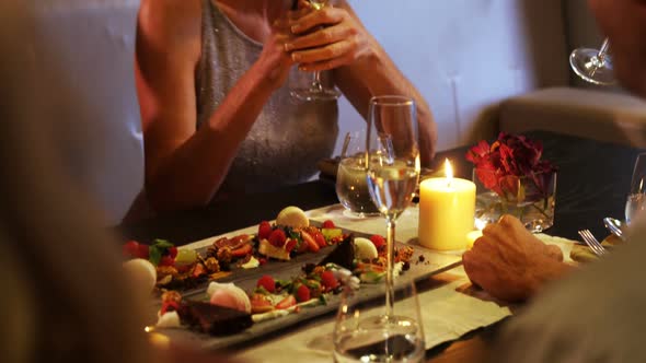 Group of friends interacting with each other while having glasses of wine 4k