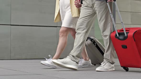 Couple with Suitcases Walking Through the Airport or Train Station