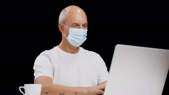 Man in Facial Mask Working on Laptop in Home Office in Coronavirus Pandemic, Manager in Protective