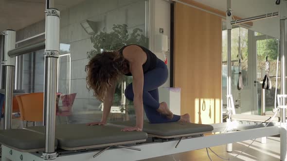 Woman doing yoga in pilates reformer