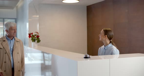 Hotel Staff Welcome Visitor and Giving Room Key After Check in