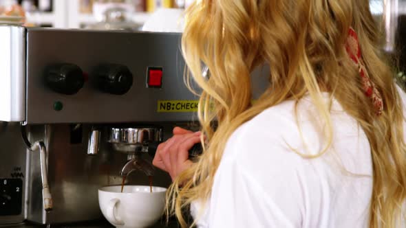 Portrait of smiling waitress making cup of coffee