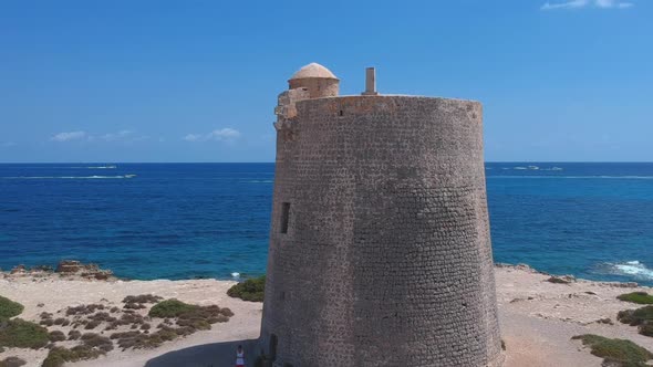 Beautiful deserted watchtower with fleet of boats in the back