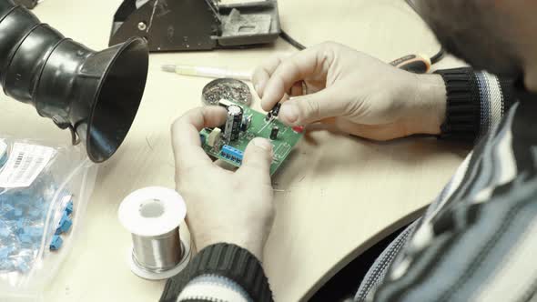 A Worker Is Working on the Creation of an Electronic Board. Close-up.