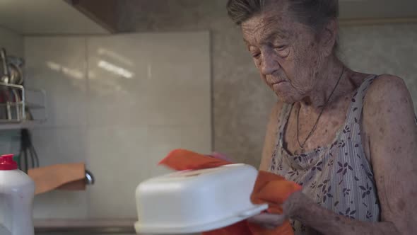 Senior Elderly Woman Washing Dishes in Kitchen