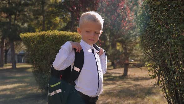 A Schoolboy in a Shirt with His Arms Crossed Over His Chest with a Backpack