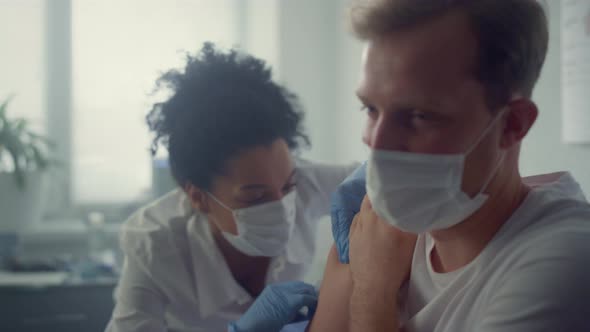 Doctor Injecting Vaccine Patient Shoulder in Health Clinic