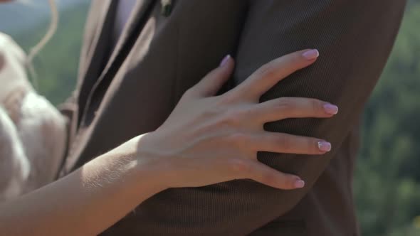 Bride Holding Hand on Groom’s Shoulder