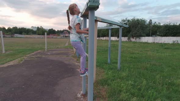 Girl Climbs On Sport Bar