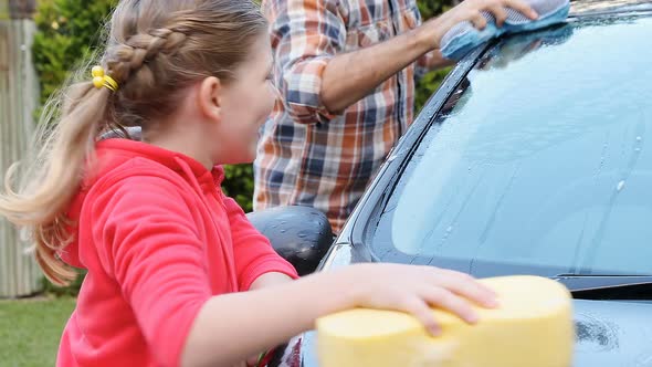 Happy daughter and father washing car with sponge 4K 4k