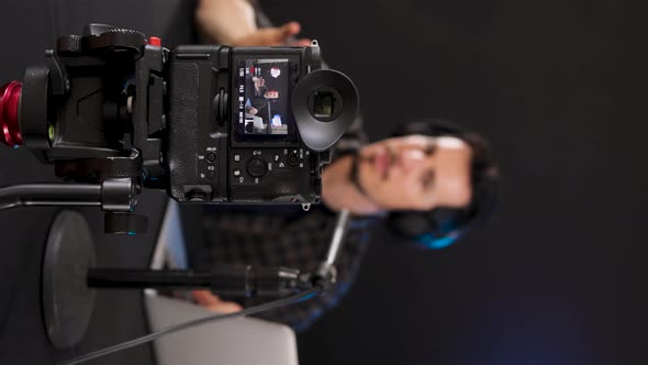 Young guy recording review vlog on camera in studio